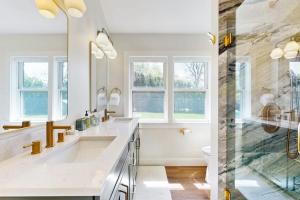 a white bathroom with two sinks and a shower at Thayer Beach Lakehouse in Colchester +52 photos