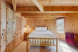 a bedroom with a bed in a wooden room at The Red Silo in Dorset