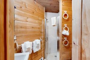 a bathroom with wooden walls and a sink and a shower at The Red Silo in Dorset +24 photos