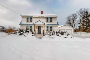 a house with snow on the ground in front of it at Pineapple Paradise in Stowe