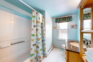 a bathroom with a shower curtain with a sink and a tub at Pineapple Paradise in Stowe +42 photos
