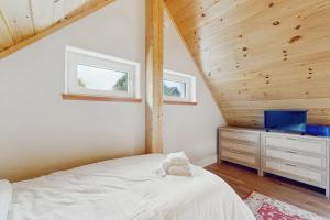 a bedroom with a white bed and a wooden ceiling at Green Mountain Zen in Ludlow