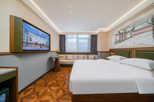 a hotel room with a large bed and a flat screen tv at Nostalgia S Hotel Beijing Guomao in Beijing