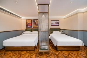 two beds in a room with two bedsvisor at Nostalgia S Hotel Beijing Guomao in Beijing