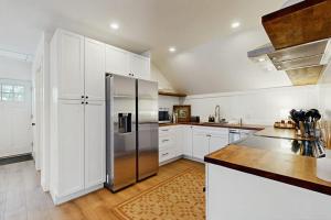 a kitchen with white cabinets and a stainless steel refrigerator at Mill Brook Retreat - Unit 2 in Waitsfield