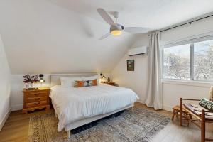 a bedroom with a bed with a ceiling fan and a window at Mill Brook Retreat - Unit 2 in Waitsfield