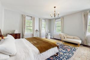a bedroom with a bed and a chair and windows at Kingdom Valley Farmhouse in Chester