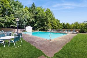 a pool with chairs and a table in the grass at South Village #8 in Warren