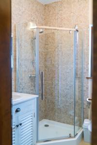 una ducha con puerta de cristal en un baño en Zestrea Bunicilor, en Bodeşti