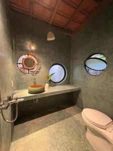 a bathroom with a toilet and a mirror at Half Village, Nha Trang in Nha Trang +8 photos