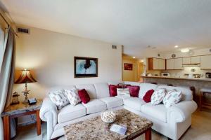 a living room with a white couch and red pillows at Okemo Mountain Condo in Ludlow