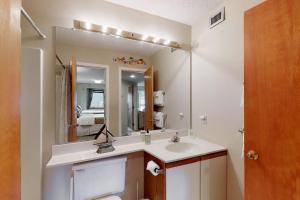 a bathroom with a sink and a toilet and a mirror at Okemo Mountain Condo in Ludlow +44 photos