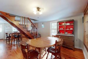 a dining room with a wooden table and a staircase at Ludlow's Gem in Ludlow