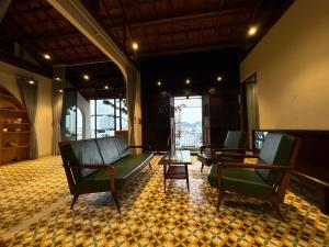 a lobby with two green chairs and a table at Half Village, Nha Trang in Nha Trang