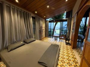 a bedroom with a large bed and a balcony at Half Village, Nha Trang in Nha Trang