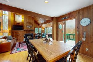 a dining room with a table and a clock on the wall at Mad River Masterpiece in Irasville