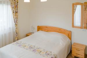 1 dormitorio con 1 cama con cabecero de madera y espejo en Zestrea Bunicilor, en Bodeşti 55 fotos más