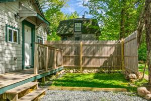 a wooden fence in front of a house at Davis Outpost Pet-Friendly Quiet Cabin w AC Screened Sunroom Walk to Trails in Otter Creek
