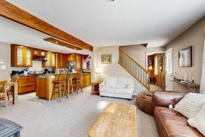 a living room with a couch and a table at Sugarbush River Home in Warren