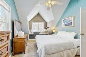 a bedroom with a white bed and a ceiling fan at Sugarbush River Home in Warren