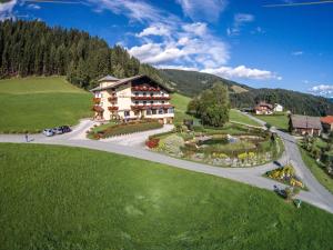 a large building on a hill with a road at Berghotel Presslauer in Jenig