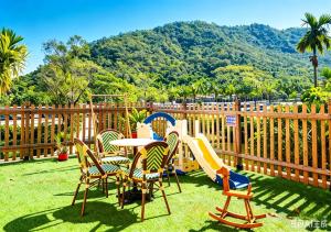 a playground with chairs and a table and a slide at Nanxiang Shushan Hotel in Sanya