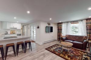 a kitchen and living room with a couch and a table at Magic Birch Lodge in Windham