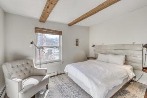 ein Schlafzimmer mit einem Bett, einem Stuhl und einem Fenster in der Unterkunft The Mill #210 in Ludlow