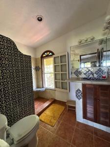 a bathroom with a toilet and a sink and a mirror at Los Dias Enmedio in Telchac Puerto +4 photos