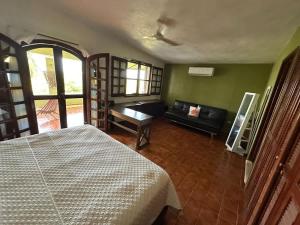 a bedroom with a bed and a couch in a room at Los Dias Enmedio in Telchac Puerto