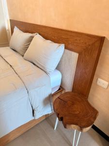 a bed with a wooden headboard and a table at Villa con rooftop para atardeceres in Telchac Puerto