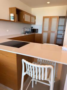 a kitchen with a counter and a white chair at Villa oasis among the palms in Telchac Puerto