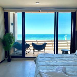 a bedroom with a bed and a view of the ocean at Villa oasis among the palms in Telchac Puerto