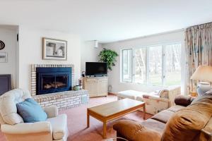 a living room with a couch and a fireplace at Vermont Paradise in Warren