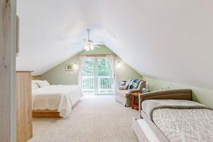 a attic bedroom with two beds and a ceiling fan at Secluded Sanctuary in West Wardsboro