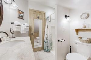 a white bathroom with a sink and a toilet at Secluded Sanctuary in West Wardsboro +105 photos