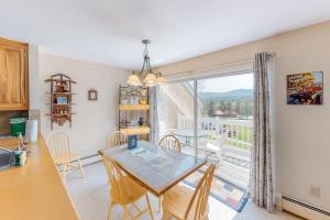 a kitchen and dining room with a table and a large window at Mountainside Resort V in Stowe
