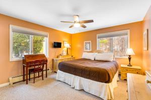 a bedroom with a bed and a desk and two windows at Mountainside Resort K204 in Stowe +61 photos