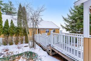 a white wooden staircase leading to a house in the snow at Mountainside Resort K204 in Stowe