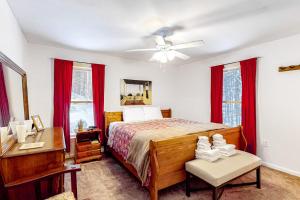 a bedroom with a bed and a desk and red curtains at Ludlow Hideout in Ludlow