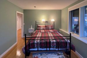 a bedroom with a bed with a red blanket and a window at Londonderry Links in Londonderry