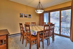 a dining room with a table and chairs and a balcony at Kettle Brook G in Ludlow +17 photos