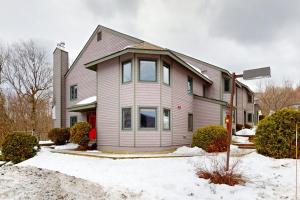 a house with a red door in the snow at The Queens Slopeside Hideaway in Jay