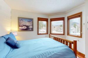 a bedroom with a blue bed and windows at The Queens Slopeside Hideaway in Jay +81 photos