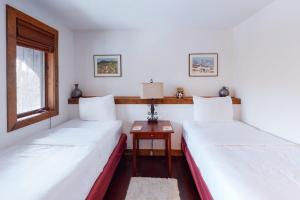 two beds in a room with a table and a window at 375 Hawk Spur in Plymouth