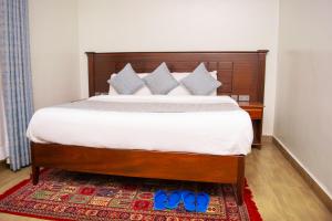 a bedroom with a bed with blue shoes on a rug at Sungura Villa in Nakuru +15 photos