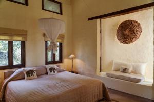 a bedroom with a bed and two windows at Tiger Tops Karnali Lodge in Bardiyā