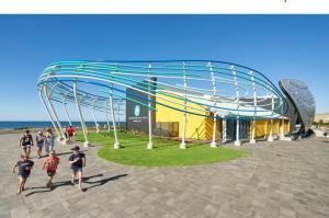 a group of people running in front of a roller coaster at Private Coastal Sanctuary Beachside Escape in Bunbury