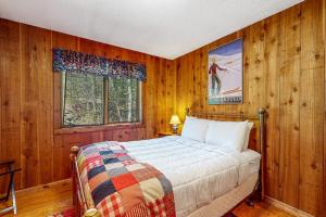 a bedroom with wooden walls and a bed in a room at 278 Ghia Farm Road in Ludlow