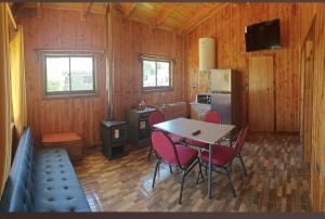 a kitchen with a table and chairs in a room at Cabaña Queule Costero in Queule